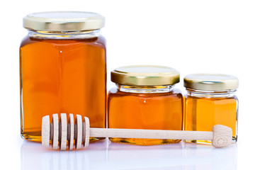 Cuillère à miel posée devant pots de miel