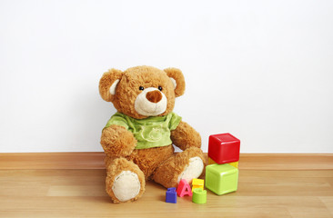 Toys - Teddy bear with cubes on laminate floor