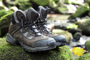 Hiking boots by stream in a forest