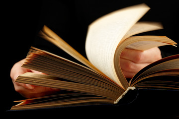 Looking thruogh book. With motion blur on black background