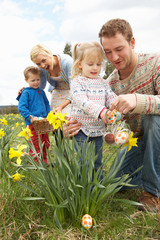 Fototapeta premium Family On Easter Egg Hunt In Daffodil Field