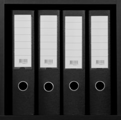 four ring binders on a bookshelf