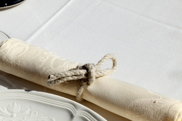 serviette nouée sur nappe blanche