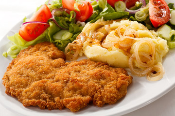 Fried pork chop with potatoes and vegetable salad
