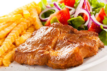 Grilled meat, French fries and vegetables