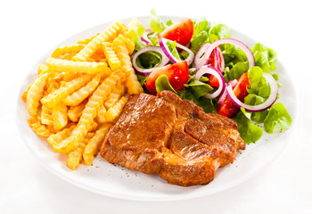 Grilled meat, French fries and vegetables