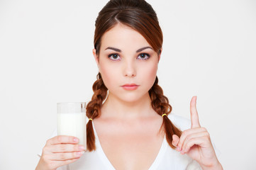 serious young woman holding glass of milk
