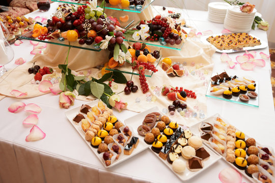 Banquet table full of sweets, fruits and berries