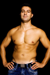 Fototapeta premium Young man with atletic body on black background