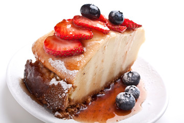 slice of tasty cheesecake with syrup and berries
