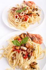 two servings of pasta with marinara sauce and seafood