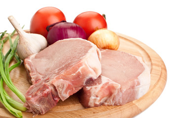 two raw pork chops with vegetables