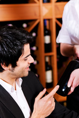 Kellnerin im Restaurant serviert Rotwein