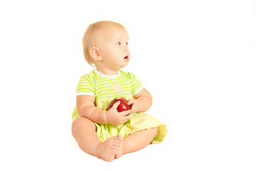 Young little baby eat red apple on white