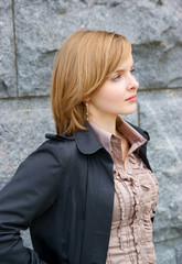 Beautiful woman near grey stone wall