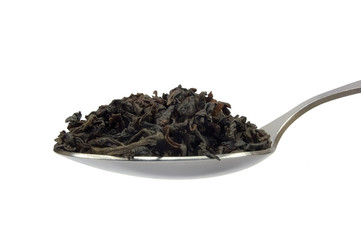 Teaspoon with black tea leaf macro, isolated