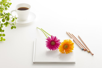 テーブルに置いたノートと花