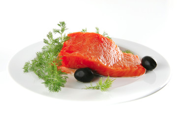 pink smoked salmon on white plate with olives