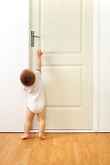 Fototapeta na wymiar Baby boy in front of door