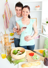 Obraz na płótnie Canvas Enamored couple drinking wine in the kitchen
