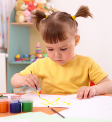 Child draws with paints in preschool