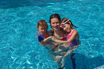 Happy mother with two children in swimming pool