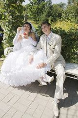 Bride and Groom  Sitting On A Park Bench