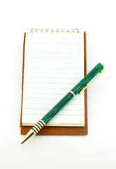 Naklejka premium notepad with pen on lower right corner isolated on white