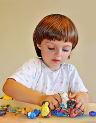 little girl playing with plasticine