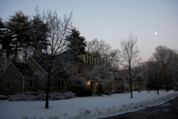 Fototapeta na wymiar Dom w opadach śniegu na zachodzie słońca