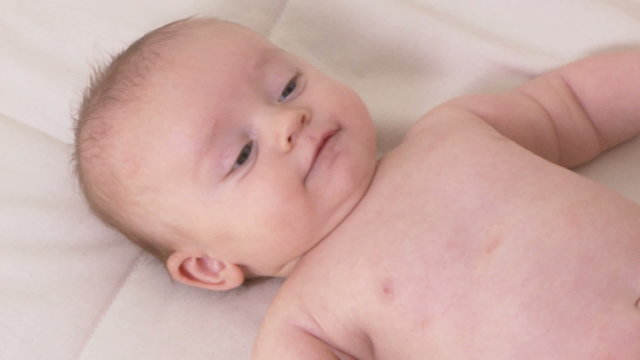 Portrait  of three month old baby laying on back