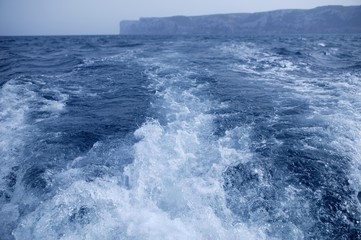 Boat ship wake with San Antonio Cape in background