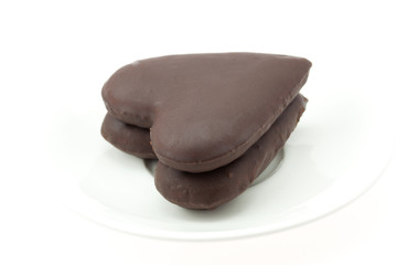 cake in a heart lying on the saucer isolated on white