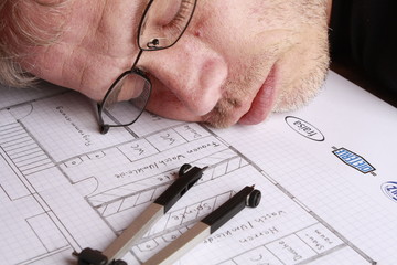 Schlafender Mann auf einer Bauzeichnung