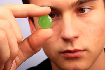 Mann mit Halsschmerztablette in der Hand