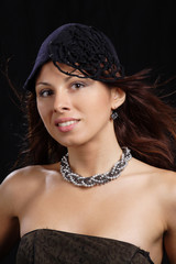 Fashion portrait of beautiful woman in hat black background