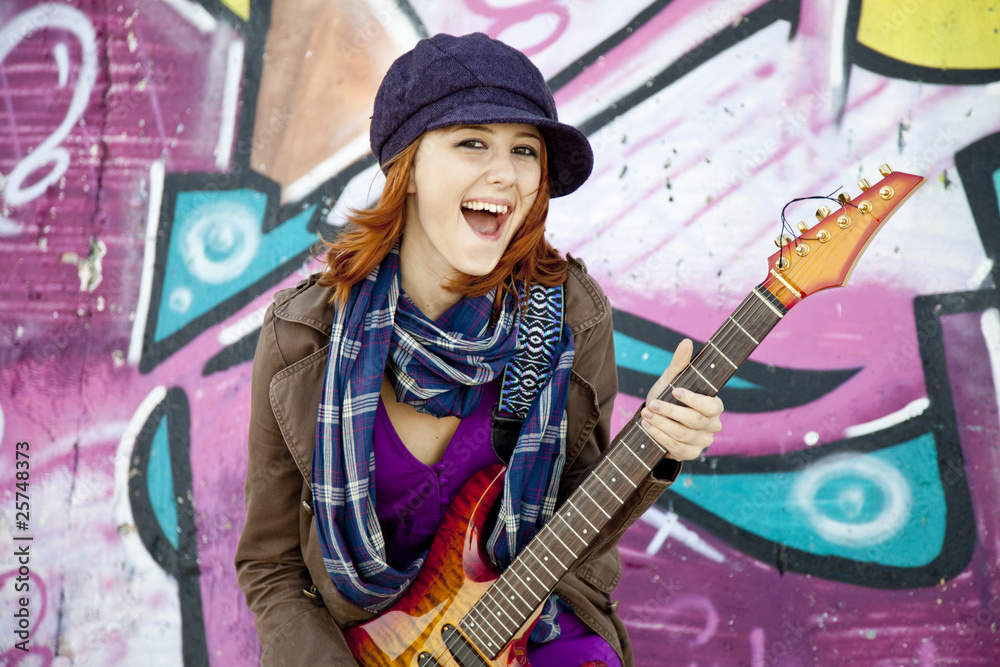 Sticker Closeup portrait of a happy young girl with guitar and graffiti