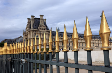 Sharp fence near Louvre, dramatic sky, France.