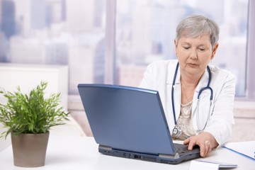 Senior doctor looking at screen