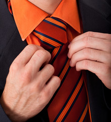 Detail of a man, fixing his tie