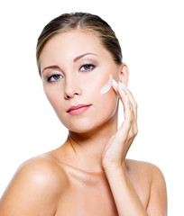Obraz na płótnie Canvas Woman applying cosmetic cream on face