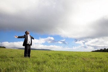 Relaxation businessman standing on the green field