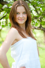 Beautiful young woman relaxing in apple tree garden