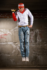 Hip hop boy dancing in modern style over grey brick wall