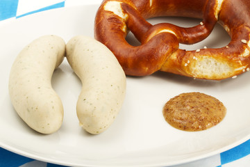 weisswürste mit süssem senf, brezel auf bayrischer tischdecke
