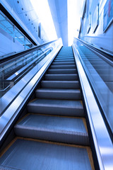 Fototapeta premium Escalator in modern interior toned in blue