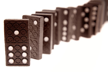 Dominoes standing in a row on white background