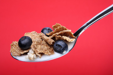 Cornflakes on spoon with blueberries