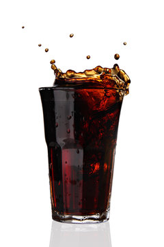 glass with cola splashing out of glass