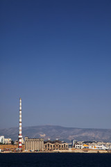 Fototapeta na wymiar Factory with chimney by a seashore